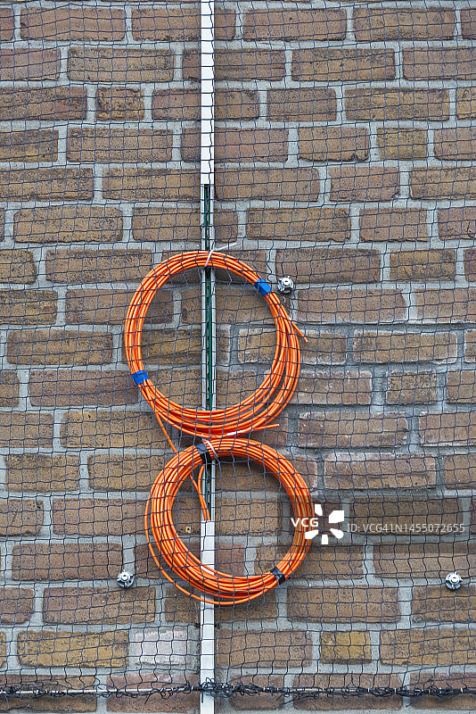 墙上悬挂的橙色卷材图片素材