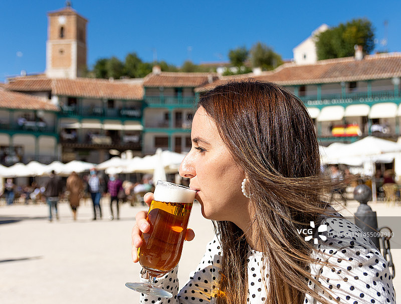 在乡村广场喝啤酒的金发女孩图片素材