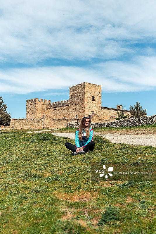 在塞戈维亚佩德拉萨城堡的年轻金发女子图片素材