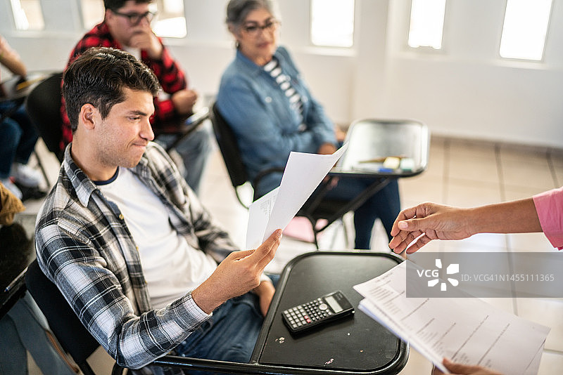 在大学教室里查看考试成绩的年轻男人图片素材