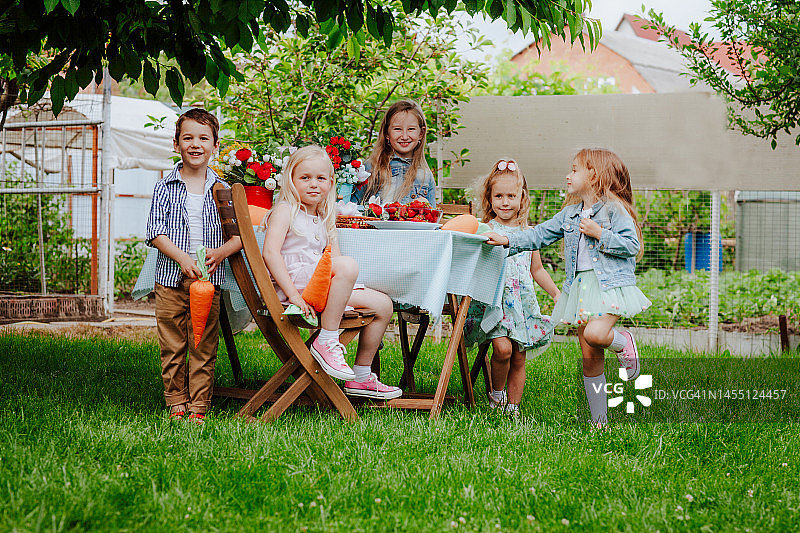 一群小朋友在后院的复活节餐桌旁玩耍图片素材