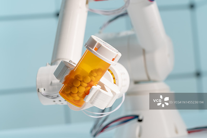 机械臂拿着药片瓶图片素材