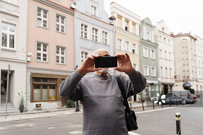 年长的男人在欧洲旅行中用手机拍照图片素材