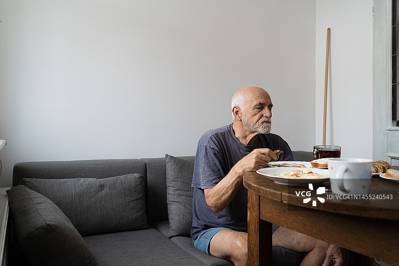 年长的男人独自在家用餐，退休生活图片素材
