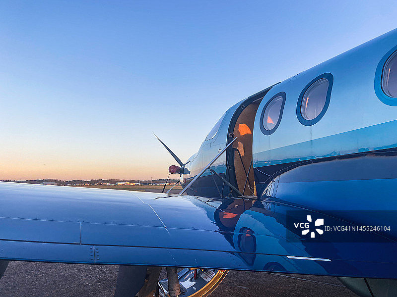 日落时分停放的单引擎涡轮螺旋桨飞机图片素材
