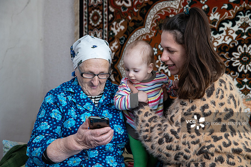女人和女儿奶奶用智能手机视频通话图片素材