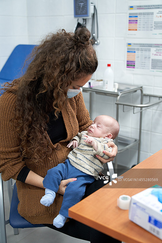母亲抱着小宝宝在儿科医生办公室等待图片素材