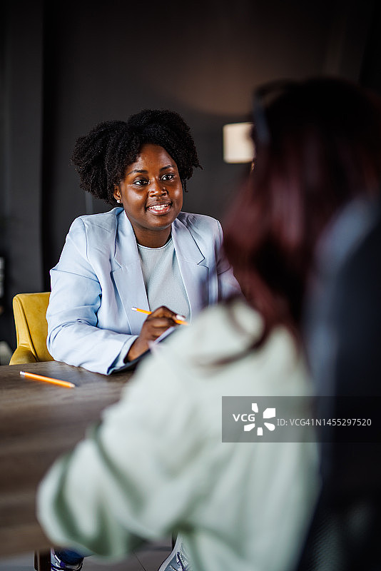 年轻女人在面试期间向经理提交文件和纸张图片素材