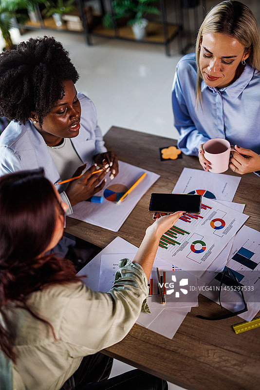 一群商务女性在项目会议期间审查各种文件图片素材