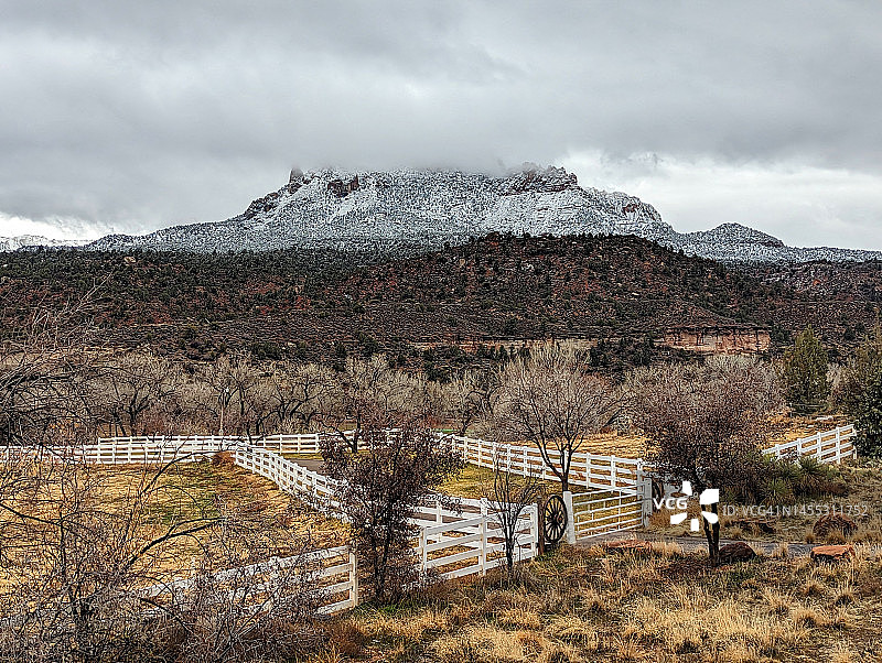 从锡安走廊风景公路（SR-9）进入斯普林代尔村，可以看到锡安国家公园入口附近的老鹰岩上空的云彩，以及红色岩石和熔岩悬崖上的新雪图片素材
