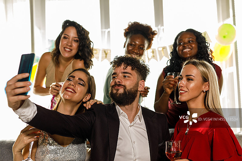 一群不同的朋友在生日派对上一起自拍图片素材