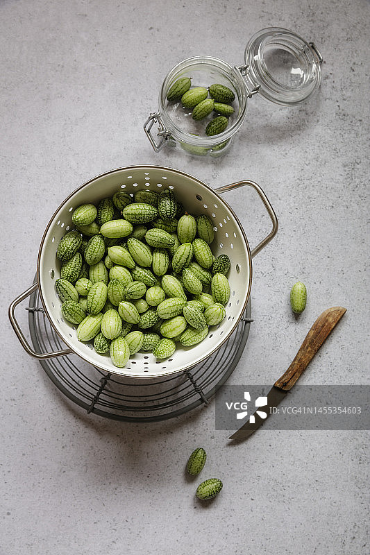 装满新鲜采摘的迷你黄瓜的漏勺图片素材