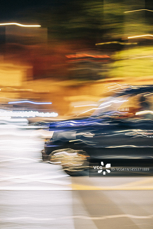 英国英格兰伦敦：夜间行驶出租车和周围交通的模糊影像图片素材