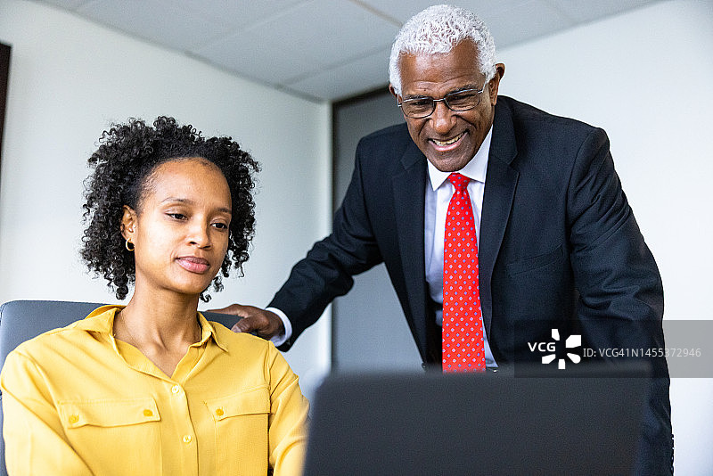老年黑人商人和妇女在会议室使用笔记本电脑图片素材