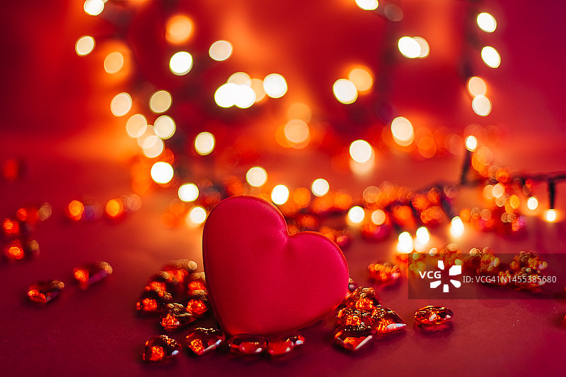 木桌上红色爱心特写，散景虚化背景，情人节概念图片素材