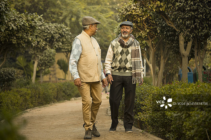 在公园里散步的两位年长的男性朋友图片素材