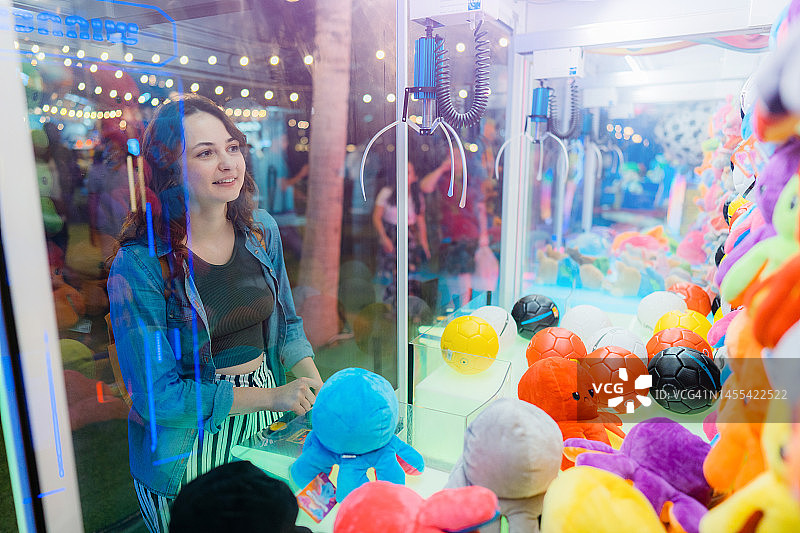 玩抓娃娃机的女人图片素材