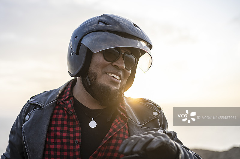 拉丁摩托车手在日落时分眺望沙漠图片素材