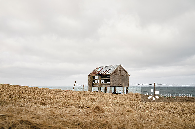 阴天里海边的简陋小屋图片素材