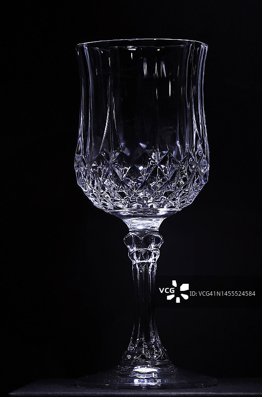 黑色背景下的单只刻面高脚杯图片素材