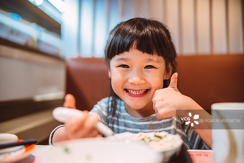 可爱的小女孩在日本餐厅用餐图片素材