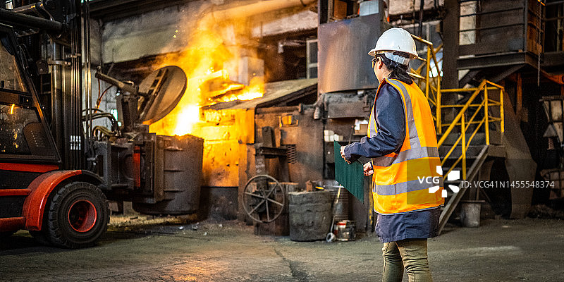 站在工厂车间，用平板电脑检查生产过程的西班牙裔女工程师图片素材