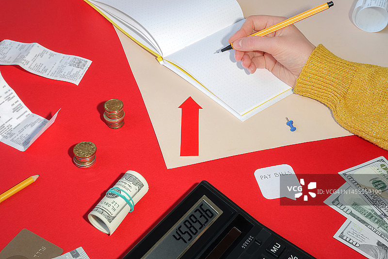 生活成本。在笔记本上手工计算。硬币、付款收据、美元和文具组合，带有复制空间。世界危机、通货膨胀、物价上涨概念图片素材