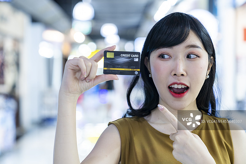 拿着信用卡的快乐年轻女人图片素材