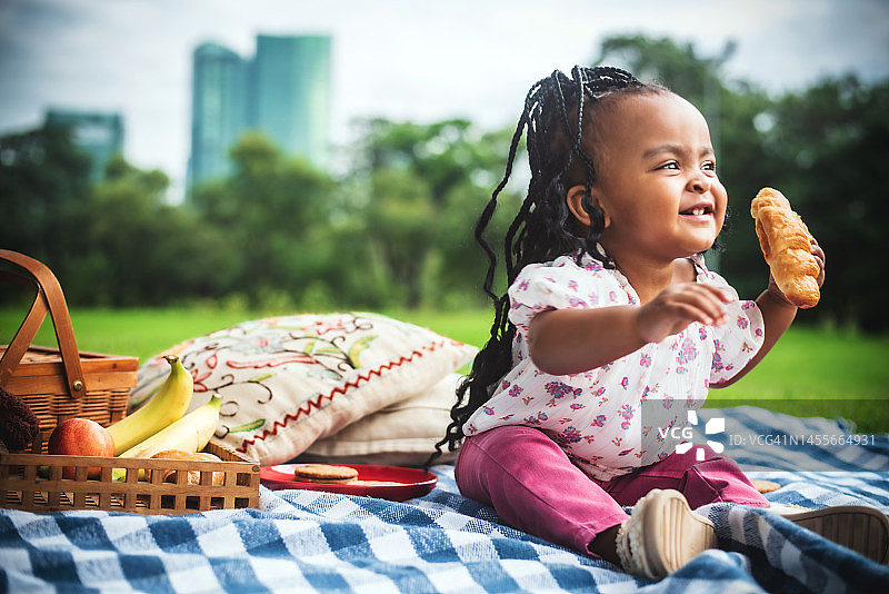 正在吃牛角包的非洲小女孩图片素材