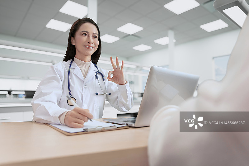 医生坐在桌前给病人开处方图片素材