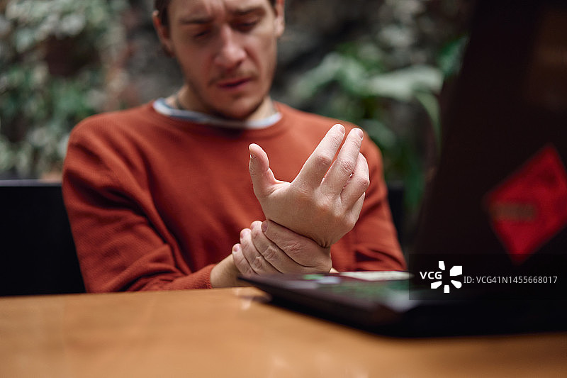 男人工作时按摩疼痛的手腕图片素材