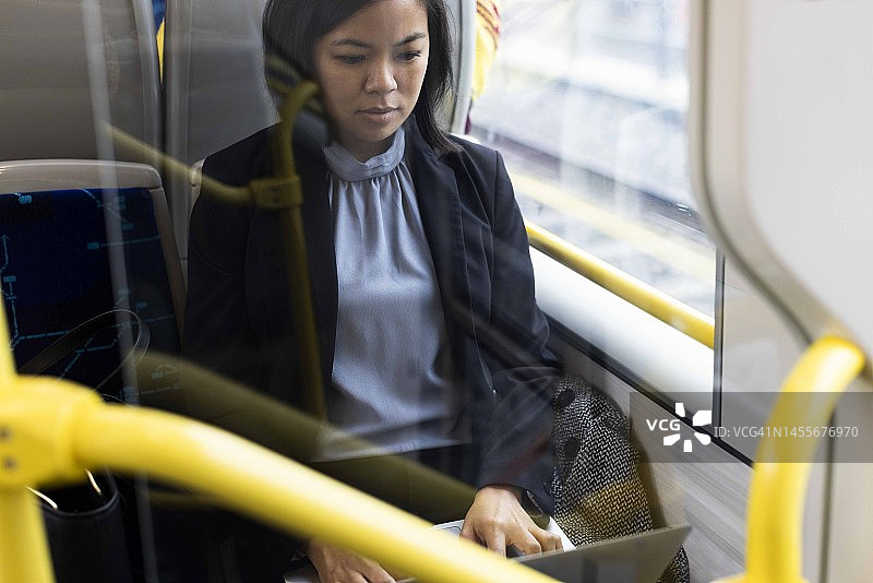 女商人坐在火车里用笔记本电脑工作图片素材