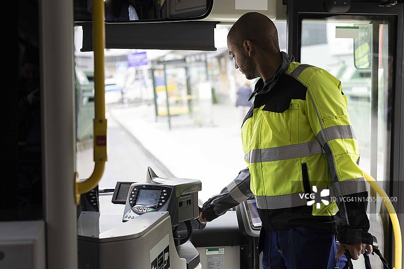 男通勤者乘坐公共汽车时使用自动检票机图片素材