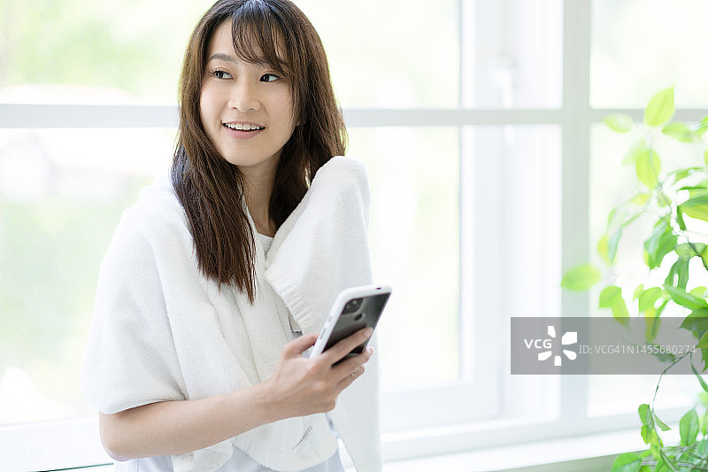 女人在窗边擦拭头发图片素材