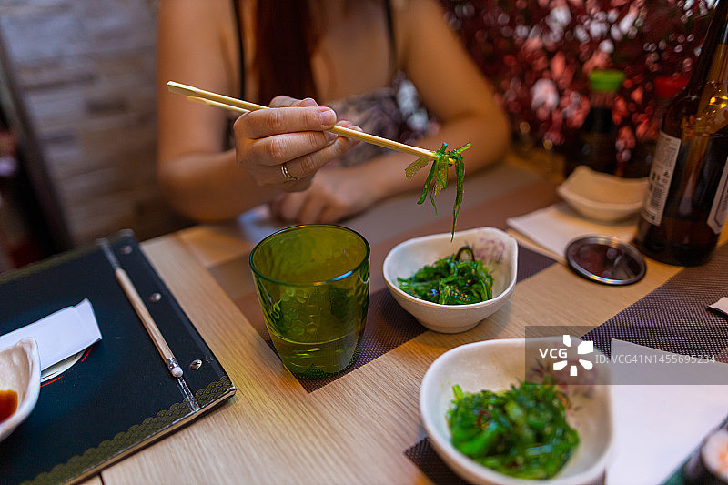正在吃日式海藻沙拉的白人妇女图片素材