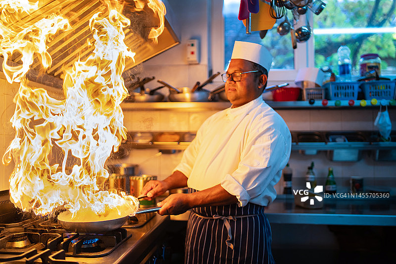 一位专业厨师正在给食物做火焰处理图片素材