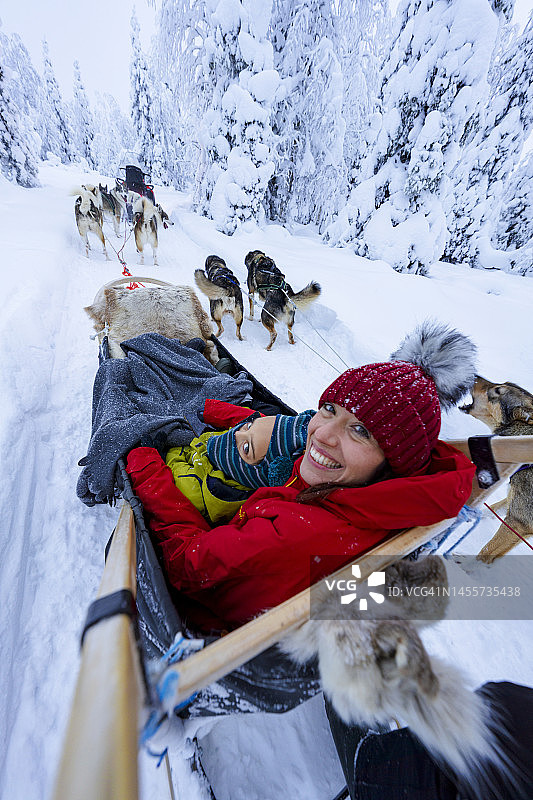 和儿子一起享受狗拉雪橇的快乐女人图片素材