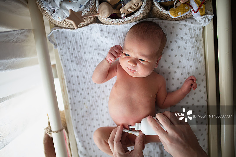 母亲用过氧化氢护理新生儿的脐带，呵护婴儿图片素材