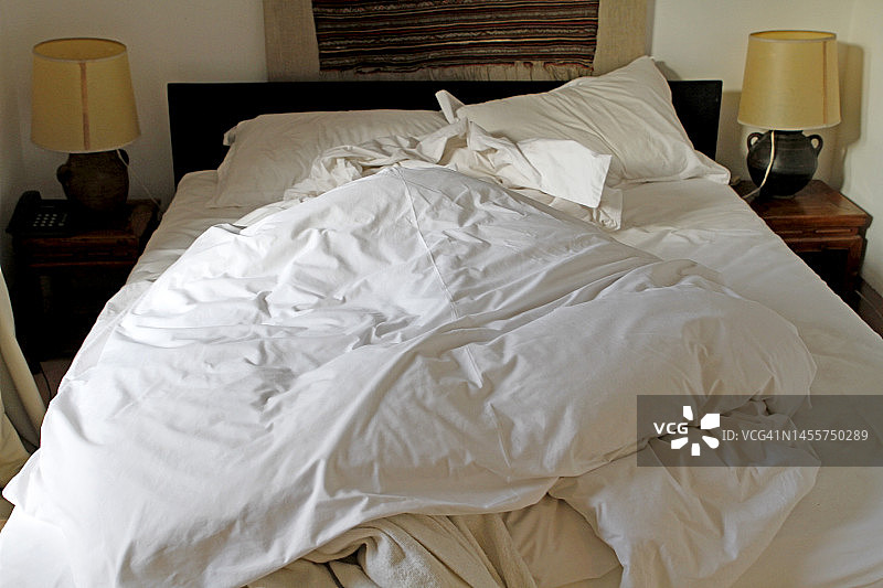 白色床单的未整理的床铺图片素材