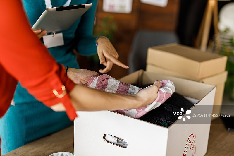 两个年轻女人整理衣物，准备捐赠做慈善图片素材