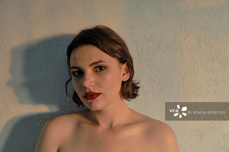 年轻女子露出肩膀，看着镜头图片素材