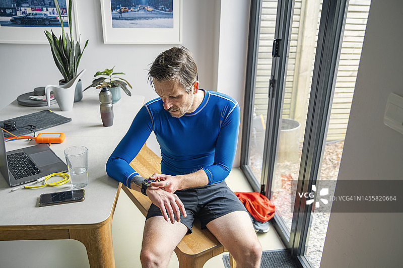 中年男人跑步后查看他的智能手表图片素材