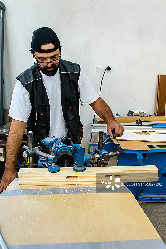 男人在车间使用砂光机图片素材