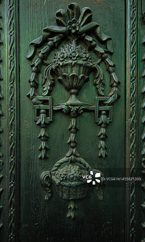 古董华丽的浮雕木制前门板，饰有扎结的蝴蝶结、装饰瓮、柳条篮和花卉等图案图片素材