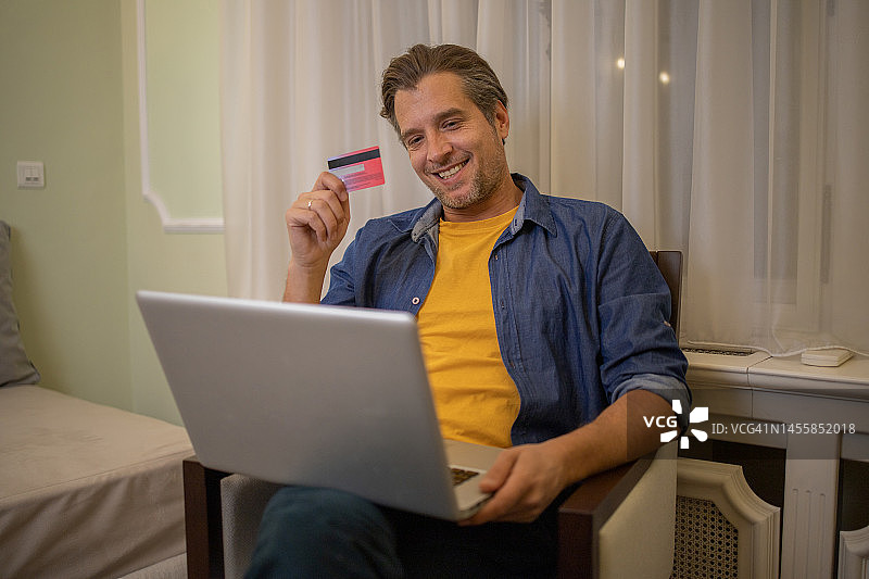 男人使用信用卡在线购物图片素材