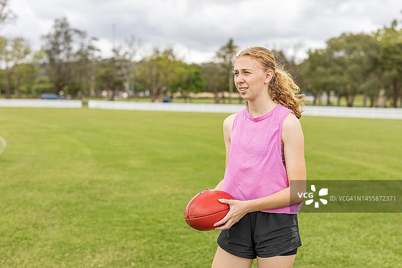 手持澳式橄榄球的少女图片素材
