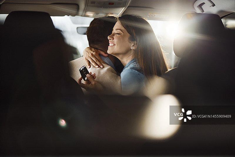 情侣购买新车后拥抱图片素材