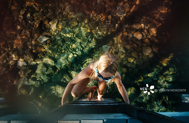 美国加利福尼亚州太浩市，女孩在湖中爬梯子的俯视图图片素材