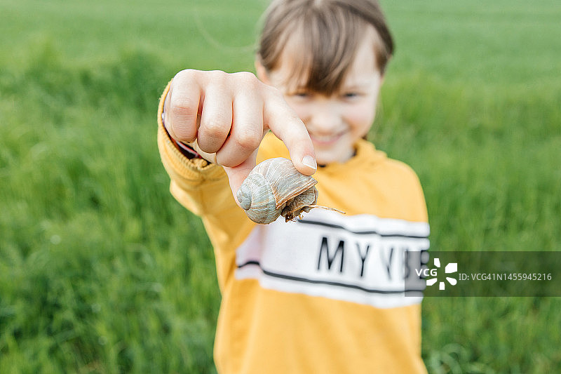 女孩双手捧着巨大蜗牛的特写图片素材