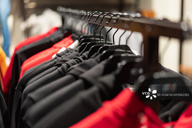 成排挂在衣架上的衣服特写图片素材